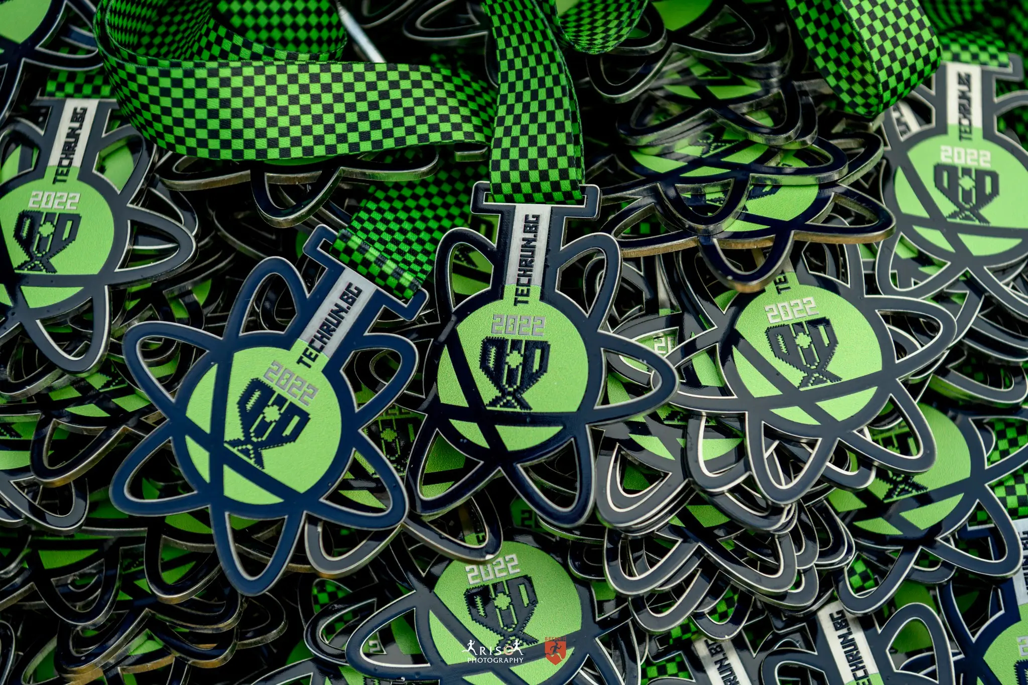 A pile of green branded medals for the winners of the Big Tech Run 2022 